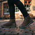 Popps 1961 MOD Mens Suede Monkey Boots in Brown, worn with dark trousers on a cobbled street