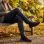 Roamers JACOB Mens Desert Boots in Dark Brown, worn by a man sitting on a park bench in autumn with dark trousers